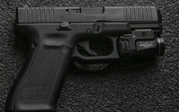 black semi automatic pistol on gray textile