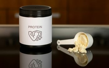 a container of protein powder next to a spoon